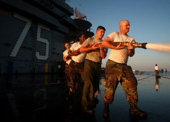 Sailors holding hose pipe